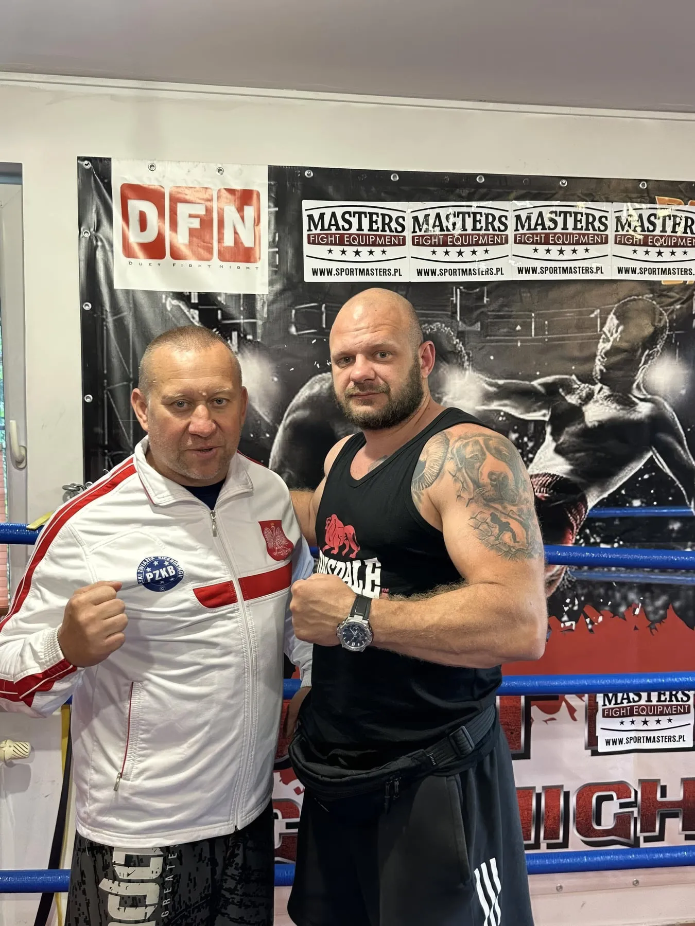 Trener i zawodnik przy banerze DFN i Masters Fight Equipment
