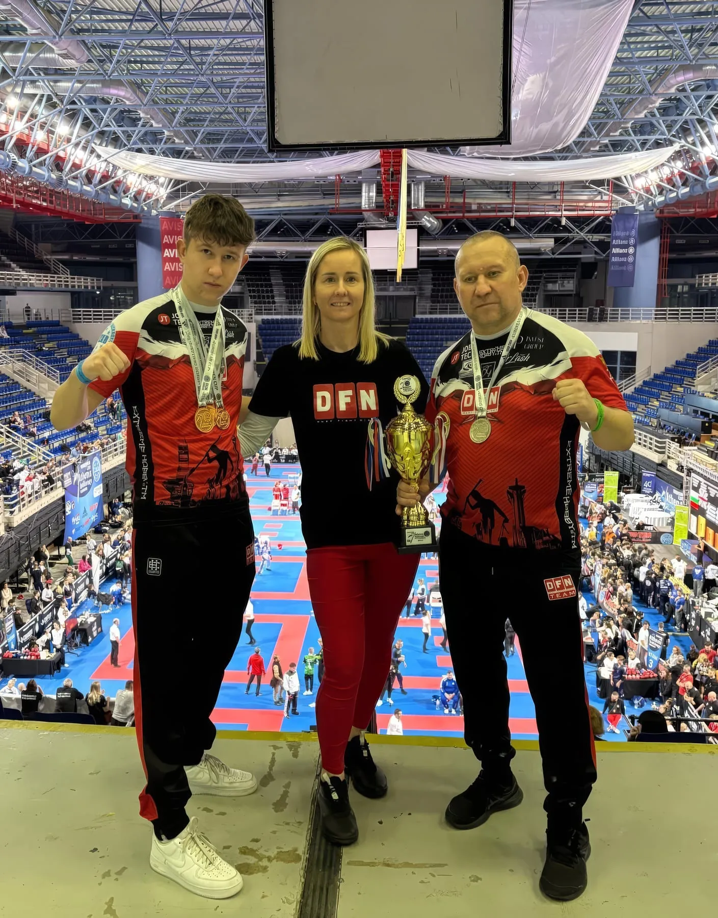 Trenerzy klubu z medalami i pucharem w hali zawodów