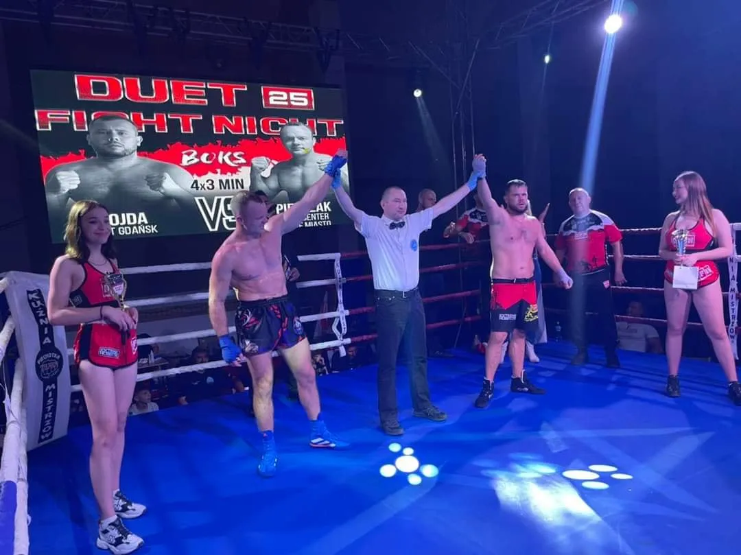 Sędzia unosi ręce zawodników po walce bokserskiej na gali Duet Fight Night 25